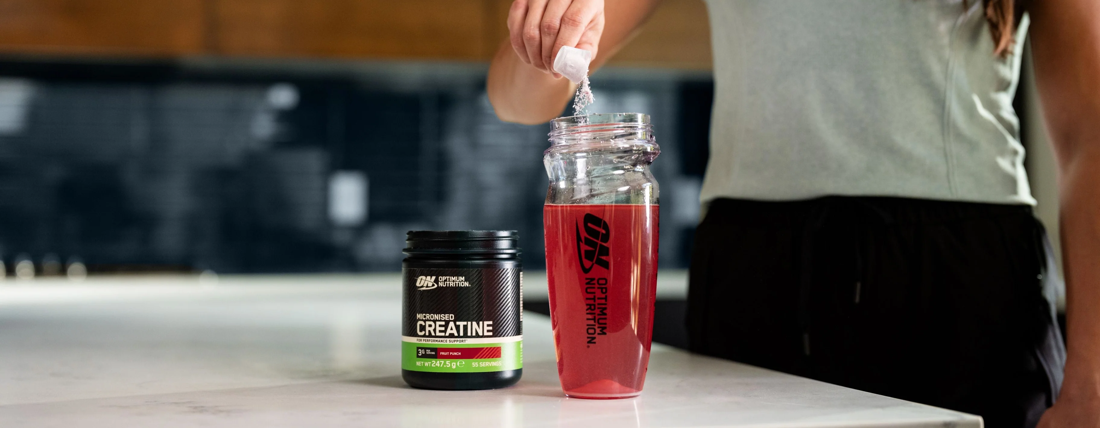 Optimum Nutrition flavoured creatine being mixed into a shaker